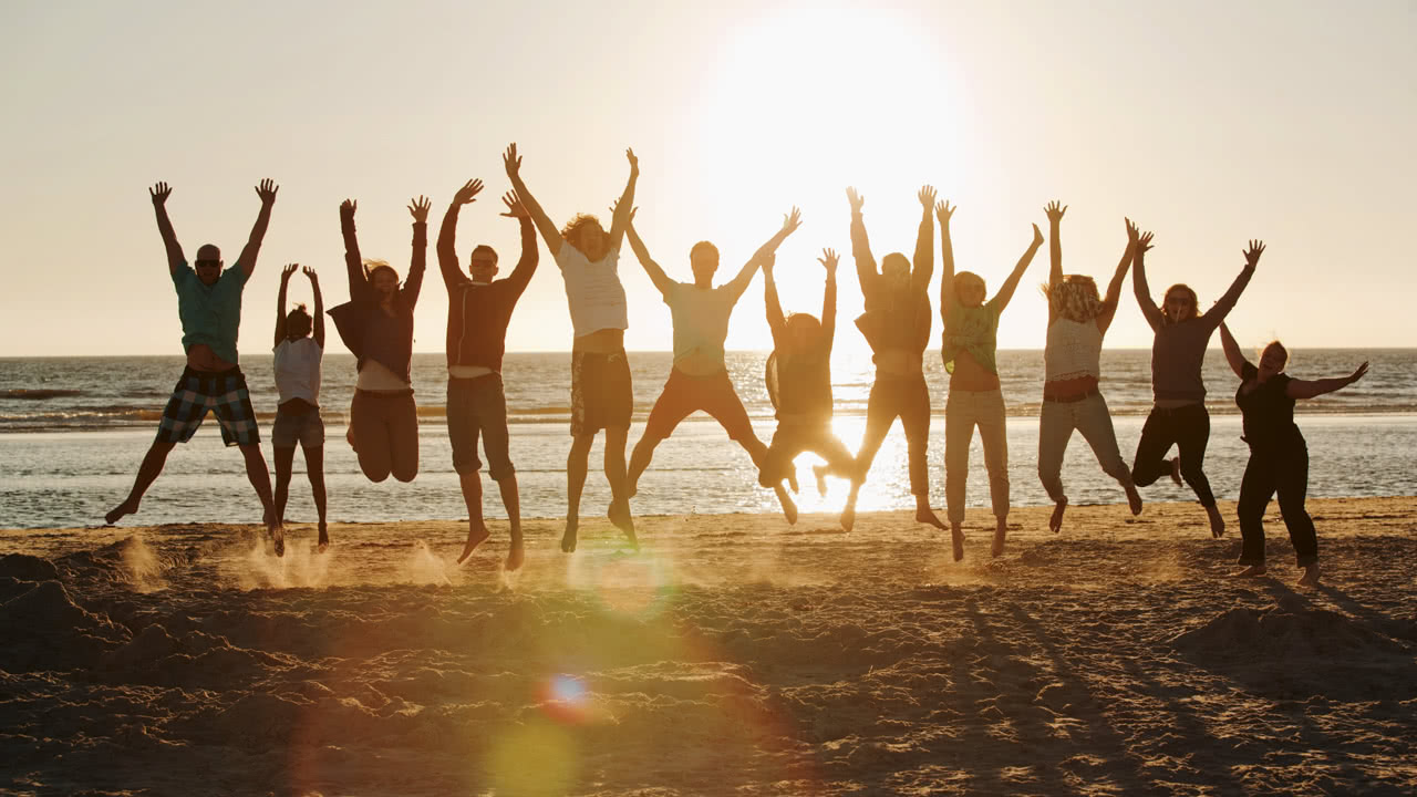 Schülergruppe am Strand im Gegenlicht